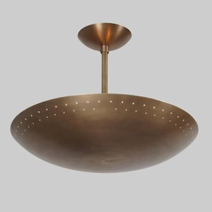 May include: A brass ceiling light fixture with a circular, saucer-shaped shade. The shade has a pattern of small holes around the edge.