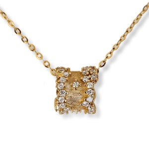 Pode incluir: Um colar de corrente de ouro com um pingente que apresenta uma banda de ouro incrustada com pequenos diamantes.