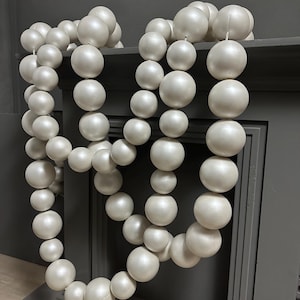 Puede incluir: Una taza de cerámica blanca con asa negra y el texto "But First, Coffee" en negrita negra. La taza se encuentra sobre un fondo neutro, resaltando su diseño sencillo.