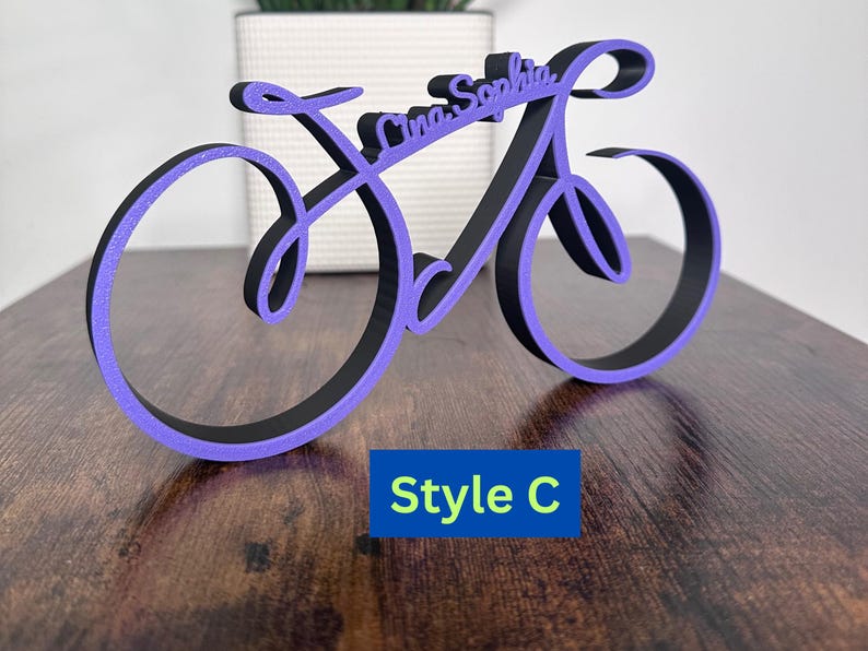May include: Purple and black wooden bicycle-shaped sign with the names "Lina Sophia" written in a cursive font. The sign is labeled "Style C".