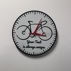 自転車時計 - 芸術作品と時計が一体となった作品。ご希望のテキストと自分で描いた線画の自転車が付いた、サイクリストへの完璧なギフトです。