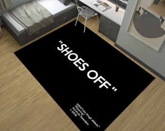 May include: Black and white rug with the text "SHOES OFF" in white lettering. The rug also includes the text "IKEA c/o Virgil Abloh™" "Flooring" "Almhult Sweden" "c 2019".