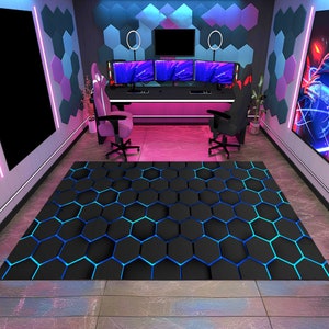 May include: A black and blue hexagonal patterned gaming mat with a blue and pink neon light background. Two gaming chairs are in the background, one on each side of the mat.