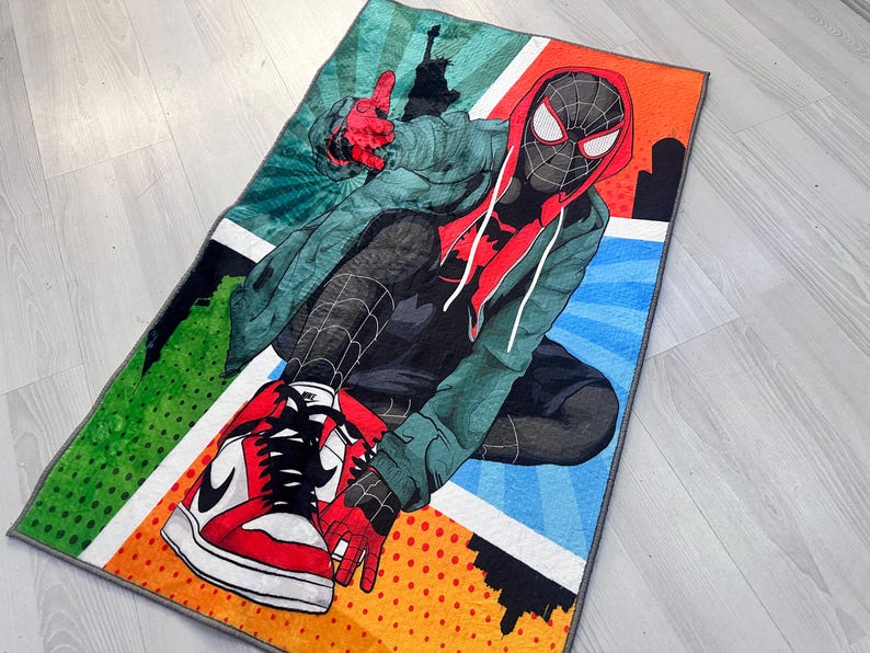 May include: A colorful rug featuring a cartoon illustration of Spider-Man wearing a red and black suit and red and white sneakers. The rug has a comic book style design with green, blue, orange, and yellow colors.