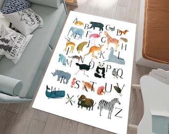 May include: A white alphabet rug with colourful animal illustrations for each letter. The rug features a variety of animals, including an elephant, giraffe, kangaroo, panda, and zebra.