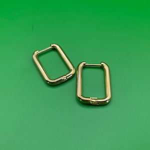 May include: A pair of gold-toned hoop earrings with a rectangular shape.