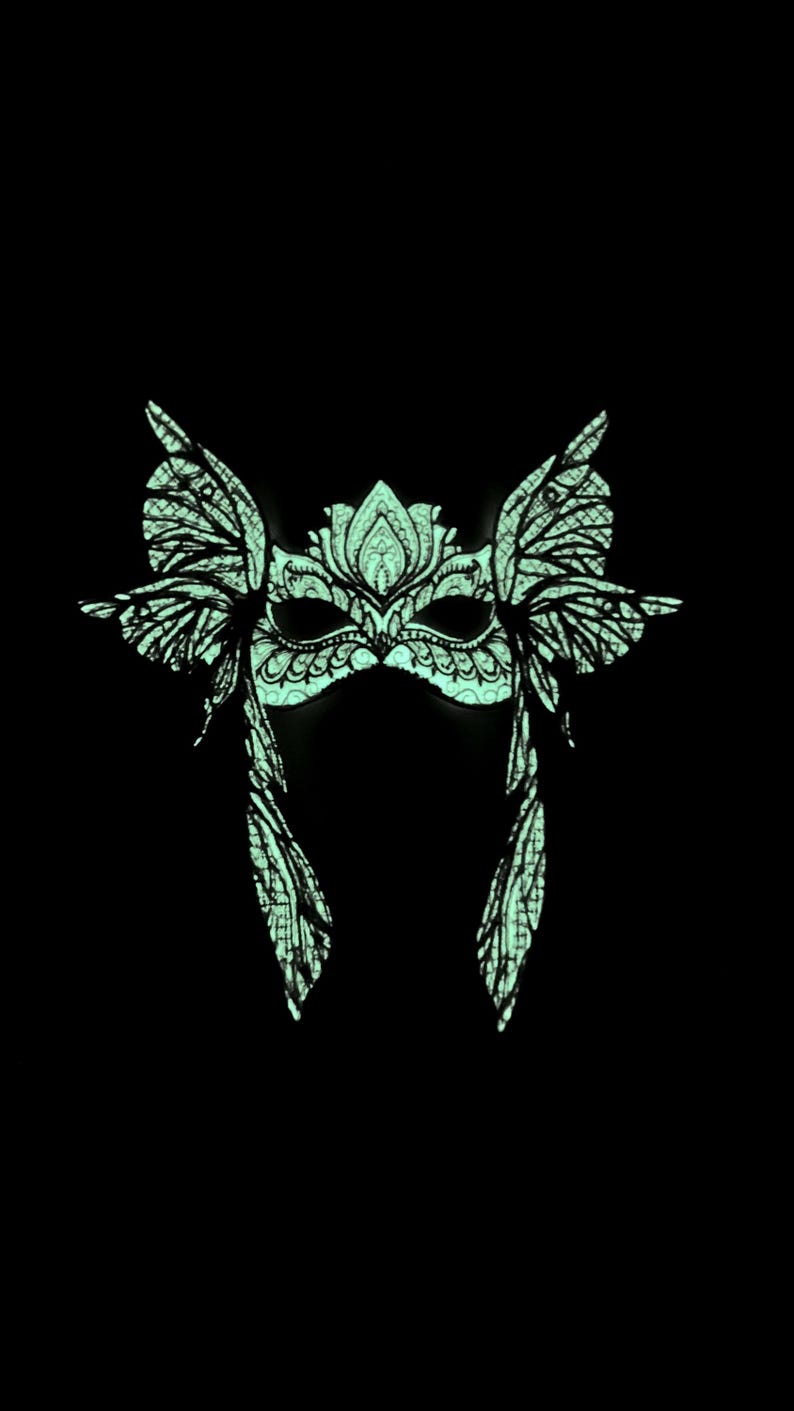 May include: A green masquerade mask with intricate butterfly wings and a floral design. The mask is made of a lightweight material and is perfect for a costume party or a masquerade ball.