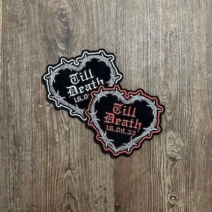 May include: Two heart-shaped patches with the words "Till Death" in gothic font, surrounded by barbed wire. One patch has a black background with white text and barbed wire, the other has a black background with red text and barbed wire.