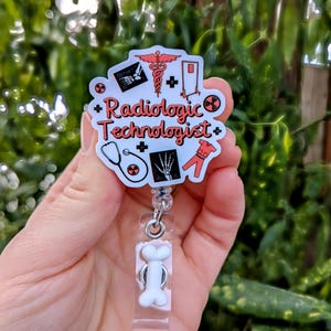 May include: White badge reel with a bone-shaped clip. The badge holder features a white background with red and black illustrations of medical symbols and the text "Radiologic Technologist".