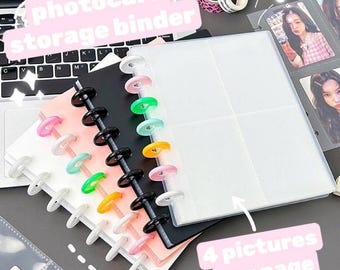 May include: A photocard storage binder with clear plastic pages that hold four pictures per page. The binder has a black cover and colorful rings.