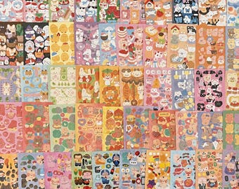 May include: A large collection of rectangular sticker sheets featuring a variety of colorful cartoon characters, animals, food items, and seasonal motifs arranged in a grid pattern. Each sheet displays unique illustrations in diverse color palettes.