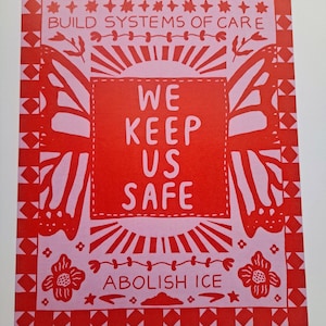 May include: A red and pink art print with the text "BUILD SYSTEMS OF CARE", "WE KEEP US SAFE", and "ABOLISH ICE". The design includes butterfly wings, floral elements, and geometric borders.