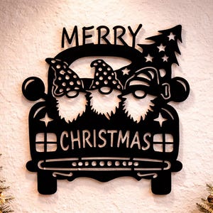 Puede incluir: Decoración navideña de metal negro con un camión que transporta tres gnomos con la inscripción "MERRY CHRISTMAS". La escena incluye una linterna encendida, regalos envueltos y pequeños árboles de Navidad.