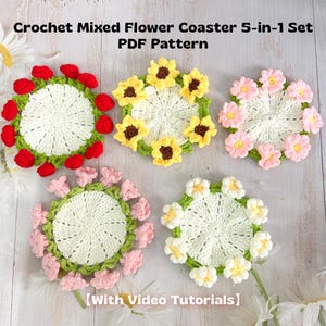May include: Five handmade crochet coasters with floral designs. Each coaster features a white center surrounded by colorful flowers, including red, yellow, and pink. The text "Crochet Mixed Flower Coaster 5-in-1 Set PDF Pattern" is visible.