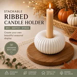 Peut inclure: Un bougeoir en céramique blanc, circulaire et nervuré, avec une bougie effilée beige clair insérée au centre. Le texte sur l'image indique : STACKABLE RIBBED CANDLE HOLDER, MIX • MATCH • STACK, Create your own beautiful seasonal display.