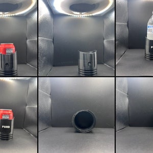 Pode incluir: Um porta-copos preto com a palavra "FORD" impressa nele. O porta-copos &eacute; mostrado com uma lata de refrigerante, uma garrafa de &aacute;gua e vazio.