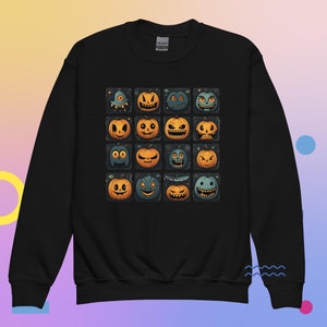 May include: Black sweatshirt featuring a grid of sixteen cartoon jack-o'-lanterns. Each pumpkin has a unique expression and color scheme, with orange, green, and blue hues. The pumpkins are set against a dark background, creating a Halloween theme.