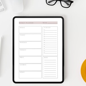 Puede incluir: Un planificador semanal en la pantalla de una tableta con un fondo blanco. El planificador tiene secciones para cada día de la semana, una lista de tareas pendientes y notas. La tableta está sobre una superficie blanca con un teclado, unas gafas, una suculenta en maceta y una taza de café.