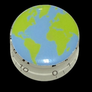 Pode incluir: Um botão de controlo circular com uma superfície superior impressa com um gráfico de mapa-mundo em azul claro e verde lima. O lado cilíndrico transparente do botão apresenta marcações numéricas pretas, incluindo 0 e 10, na base.