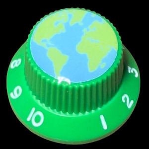May include: A round green control knob with a ridged edge and a flat top featuring a blue and light green map of the world. The base of the knob has white printed numbers ranging from 1 to 10 around the circumference of the green surface.