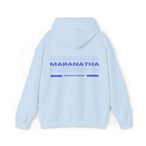 May include: Light blue hooded sweatshirt with the text "MARANATHA" repeated multiple times in blue on the back. The text "CRISTO VIENE!" is also printed in blue on the back.