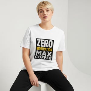 Puede incluir: Camiseta blanca con el texto "ZERO MOTIVATION MAX COFFEE" en un diseño rectangular negro y amarillo. La camiseta la lleva una persona con el pelo corto rubio y pantalones negros.