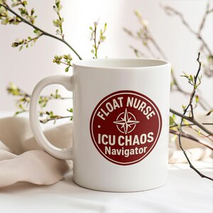 May include: White ceramic mug with a handle. The mug features a maroon circular design with the words "FLOAT NURSE", "ICU CHAOS", and "Navigator" in white, along with a compass rose graphic. The mug is on a white surface.