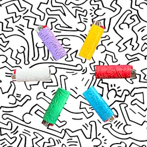 May include: Six colorful lighters arranged in a star shape on a white background with a black and white pattern of stick figures. The lighters are purple, yellow, red, white, green, and blue.