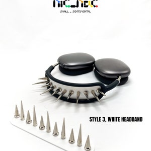 May include: Gray headphones with a white headband featuring silver spikes. A white base holds additional silver spikes. The text "STYLE 3, WHITE HEADBAND" is displayed. The brand logo "nic_jac" is at the top.