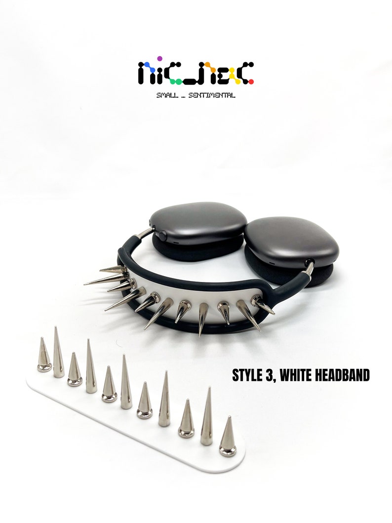 May include: Gray headphones with a white headband featuring silver spikes. A white base holds additional silver spikes. The text "STYLE 3, WHITE HEADBAND" is displayed. The brand logo "nic_jac" is at the top.