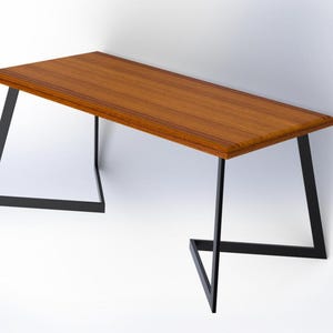 Op de afbeelding: Een houten tafel met een rechthoekig blad en zwarte metalen poten. De poten zijn driehoekig en in het midden met elkaar verbonden.