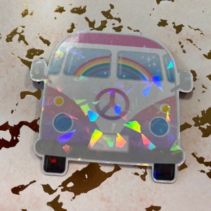 May include: A holographic sticker of a vintage van with a peace sign and rainbow. The van is pink, white, and blue with a holographic finish.