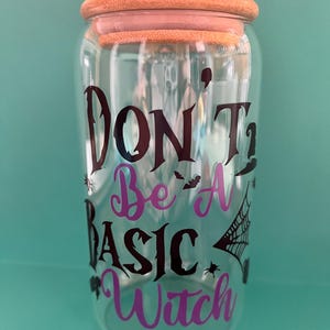 Op de afbeelding: Een glazen pot met een houten deksel en een zwarte en paarse vinyl sticker met de tekst "Don't Be A Basic Witch".