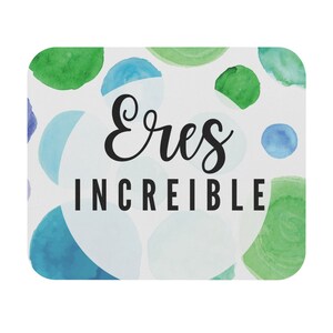 May include: A white square coaster with a watercolor design of blue and green circles. The words "Eres Increíble" are written in black script and block letters.