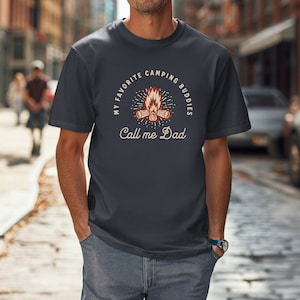 May include: A dark blue t-shirt with a campfire graphic and the text "My Favorite Camping Buddies Call me Dad".