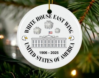 May include: White ceramic Christmas ornament featuring the White House East Wing with fireworks and an American flag. The ornament includes the text "White House East Wing United States of America 1906-2025" and two eagle illustrations.