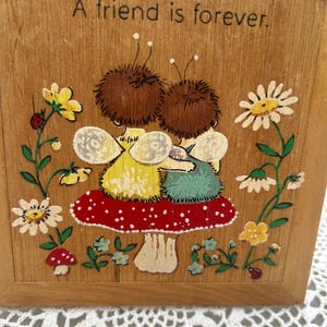 Cuadro vintage de madera pintado a mano de los años 70 con una niña de pie, abejas abrazándose y sentadas sobre un hongo. Tarjetas Hallmark de Springbook "Los amigos son para siempre".