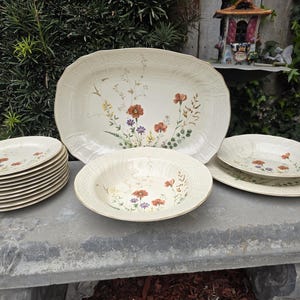 May include: A set of three ceramic mugs with a speckled, matte finish. The mugs are in shades of cream, light gray, and dark gray. Each mug has a simple, minimalist design, perfect for coffee or tea.