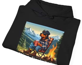 May include: Black hoodie featuring a graphic of a Rottweiler dog wearing a plaid shirt and sitting in a camping chair by a campfire in a woodland setting. The text "Wild Dogs" is visible at the bottom of the graphic.