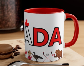 May include: White ceramic mug with a red rim and handle. The mug features a red and black graphic of the word "CANADA" with a Canadian flag, a cartoon person, a goose, hockey sticks, and a bear.
