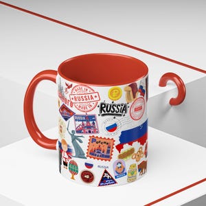 Peut inclure: Une tasse en céramique blanche avec un intérieur et une anse rouges, ornée de divers autocollants et timbres sur le thème de la Russie. La tasse présente le mot "RUSSIA" en gras et des images de monuments et de symboles culturels.