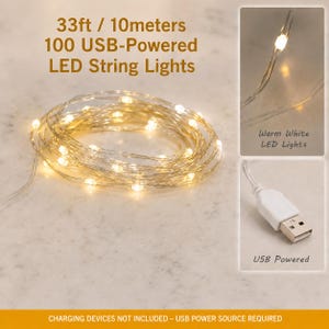 May include: A 33ft string of 100 USB-powered LED lights with warm white bulbs on a thin wire. The set includes a white USB connector. Text on the image reads: 33ft / 10meters 100 USB-Powered LED String Lights, Warm White LED Lights, USB Powered.
