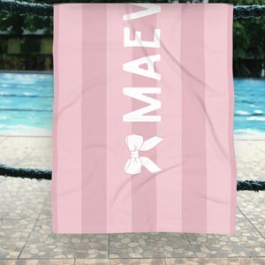 This custom coquette bow beach towel is the perfect blend of style and function for kids and teens. Designed with a personalized name and trendy bow detail, this custom pool towel makes a great vacation towel gift or summer accessory. Soft and absorbent, it’s ideal for beach days, poolside lounging, and travel, making it a fun and unique gift idea for girls!