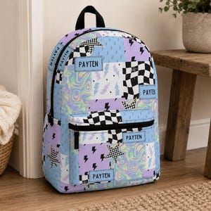 Pastel checkered backpack featuring a customizable name and modern colorful design. Durable everyday bag perfect for school, travel, sleepovers, and extracurricular activities. Comfortable backpack for kids and teens who love trendy, personalized accessories.
