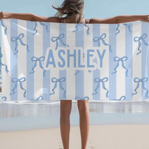 Custom name coquette bow beach towel in a stylish design, perfect for girls, teens, and kids. A personalized pool towel ideal for spring break, vacations, and bachelorette gifts. This trendy custom color towel makes a great gift idea for any occasion.