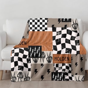 This custom boy baby blanket features a personalized name with a cool skeleton hand and lightning bolt design, adding a fun, spooky touch to nursery decor. It’s the perfect cozy kids blanket for fall, Halloween, or year-round for boys who love edgy style. This unique personalized blanket makes a great boy gift idea and brings playful, cool vibes to any boy’s room or nursery