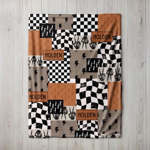 This custom boy baby blanket features a personalized name with a cool skeleton hand and lightning bolt design, adding a fun, spooky touch to nursery decor. It’s the perfect cozy kids blanket for fall, Halloween, or year-round for boys who love edgy style. This unique personalized blanket makes a great boy gift idea and brings playful, cool vibes to any boy’s room or nursery