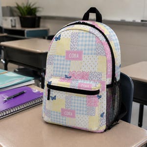 Patchwork style backpack featuring soft pastel patterns and customizable name detail. Durable everyday bag perfect for school, travel, sleepovers, and daily adventures. Trendy design for kids and teens who love colorful, feminine, vintage inspired accessories.