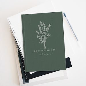 May include: A dark green journal with a white line drawing of a bouquet of flowers and the text "DO EVERYTHING IN LOVE" in white.