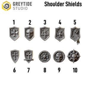 May include: A collection of ten gray shoulder shields with various designs, including crosses, skulls, and geometric patterns. The shields are numbered 1 through 10 and are likely for miniature figures or cosplay.